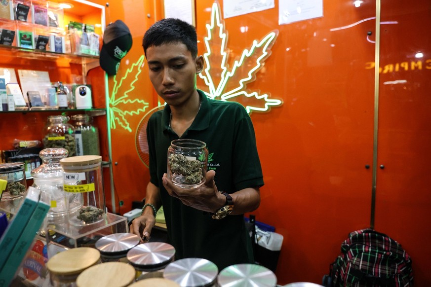 January 17, 2024, Bangkok, Thailand: A vendor holds a jar containing cannabis for sale at a cannabis dispensary in the Nana district in Bangkok, Thailand, January 17, 2024. The new Thai government has ...