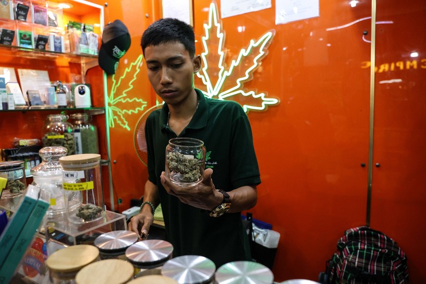 January 17, 2024, Bangkok, Thailand: A vendor holds a jar containing cannabis for sale at a cannabis dispensary in the Nana district in Bangkok, Thailand, January 17, 2024. The new Thai government has ...