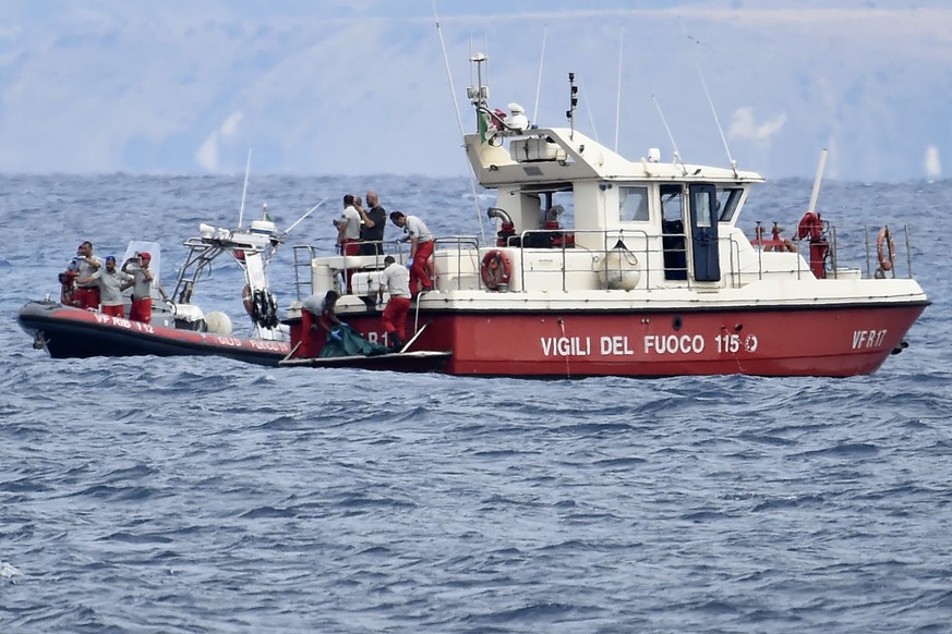 Italian Firefighters scuba divers bring ashore in a green bag the body of one of the victims of the UK flag vessel Bayesian, Wednesday, Aug. 21, 2024. The sail yacht was hit by a violent sudden storm  ...