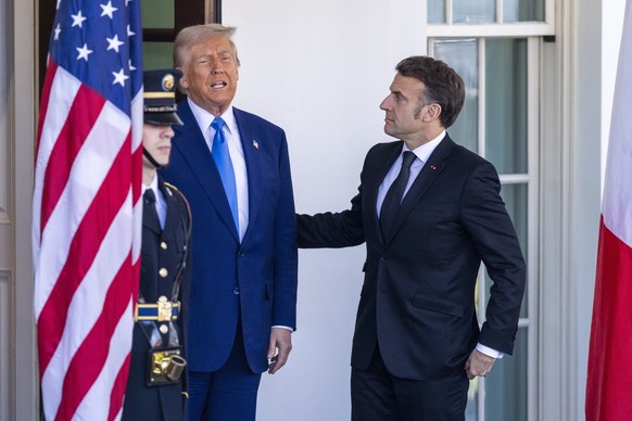 epa11921974 US President Donald J. Trump (L) and French President Emmanuel Macron respond to a question from the news media as President Macron arrives at the White House in Washington, DC, USA, 24 Fe ...