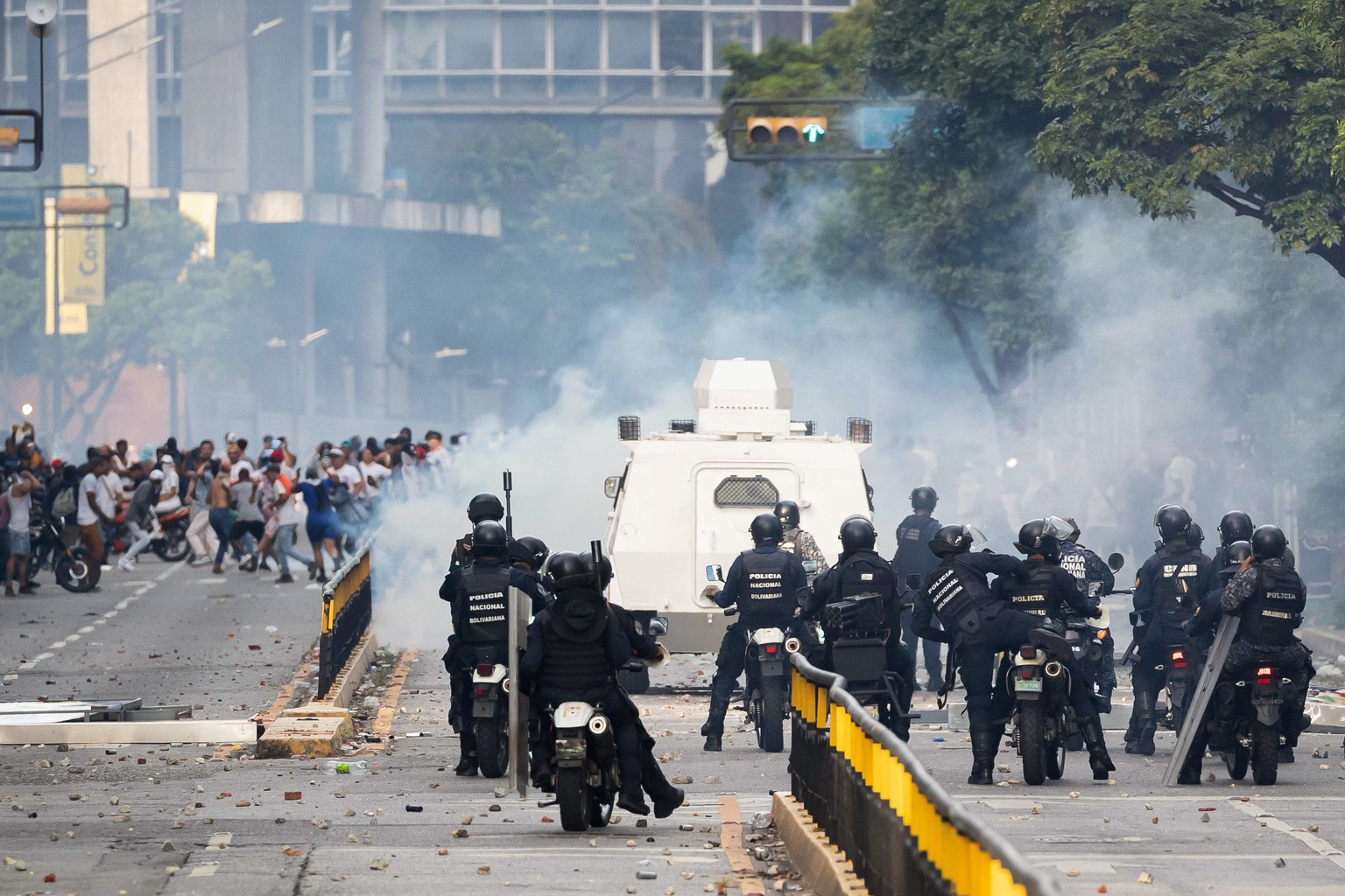 epaselect epa11507675 Members of the Bolivarian National Police (PNB) and the Bolivarian National Guard (GNB) clash with opposition demonstrators during protests over the results of the presidential e ...