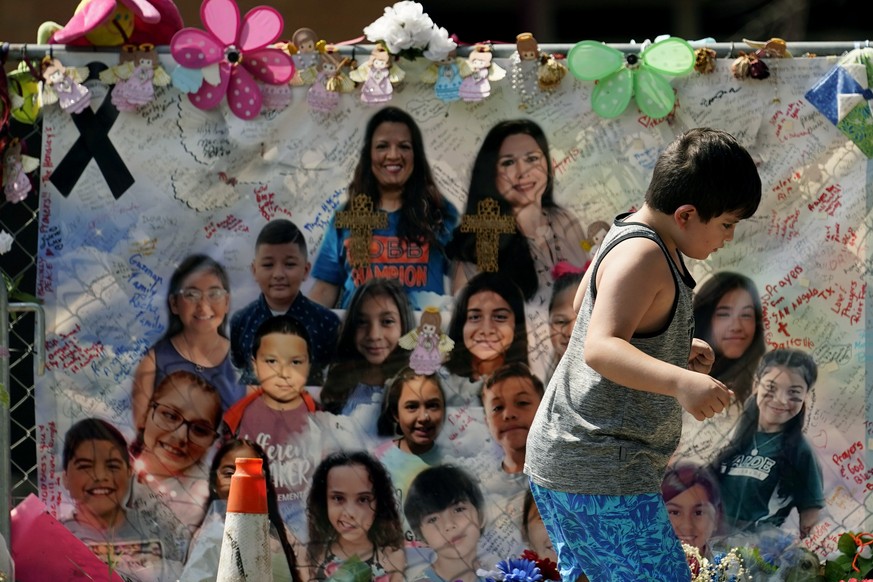 A young boy walks past a makeshift memorial honoring those recently killed at Robb Elementary School, Tuesday, July 12, 2022, in Uvalde, Texas. A Texas lawmaker says surveillance video from the school ...