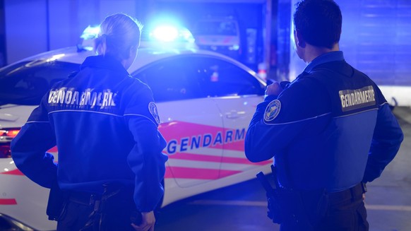 [Editor's note: photo mise-en-scene] A patrol of the cantonal police of Vaud stands in front of their their car with blue lights switched on, photographed in Cugy, in the Canton of Vaud, Switzerl ...