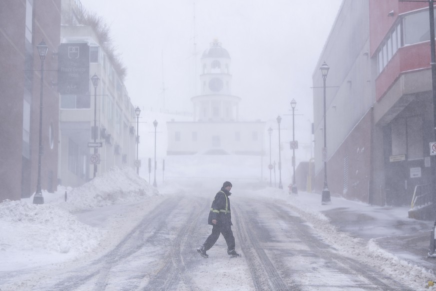 A pedestrian makes their way through the downtown as heavy snow and gusting winds continue to hit Halifax, Nova Scotia, on Sunday, Feb. 4, 2024. Environment Canada has maintained weather alerts across ...