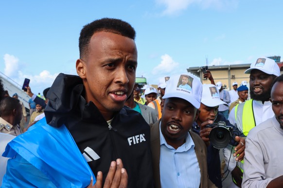 epaselect epa13027751 FIFA referee Omar Abdulkadir Artan (C) is greeted by supporters upon his arrival at the airport in Mogadishu, Somalia, 10 June 2026. Artan was given a hero's welcome after U ...