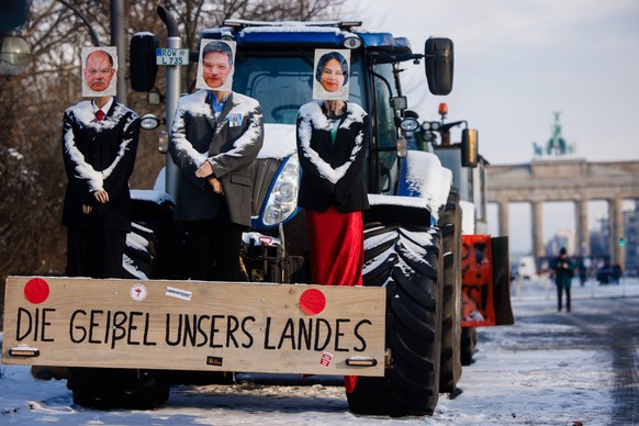 epa11087923 A tractor is decorated with mannequins with photos of German Chancellor Olaf Scholz (L), German Minister for Economy and Climate Robert Habeck (C) and German Foreign Minister Annalena Baer ...
