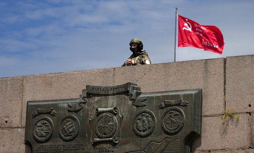 FILE - A Russian soldier guards an area by the Alley of Glory exploits of the heroes - natives of the Kherson region, who took part in the liberation of the region from the Nazi invaders, in Kherson,  ...