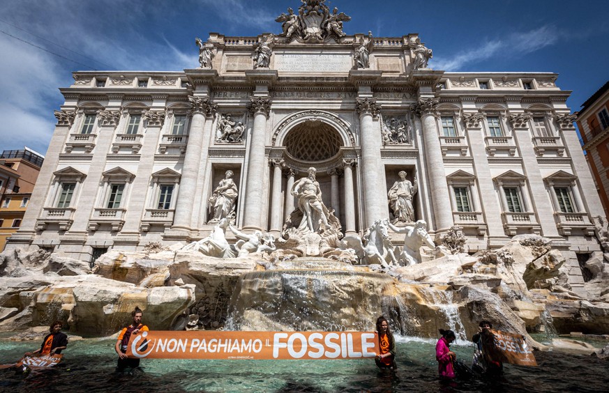 epaselect epa10643122 Climate activists from the group &#039;Last Generation&#039; stand inside the Trevi Fountain in Rome, Italy, 21 May 2023. About a dozen activists, who recalled the emergency in t ...