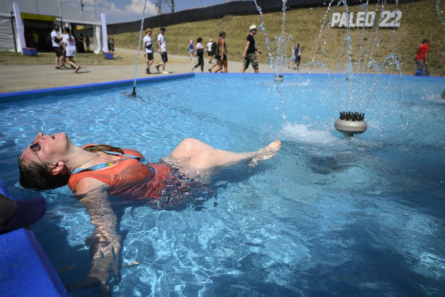 Festivalgoer Sarah cools off in a water fountain during the heat wave the first day of the 45th edition of the Paleo Festival, in Nyon, Switzerland, Tuesday, July 19, 2022. The Paleo is the largest op ...