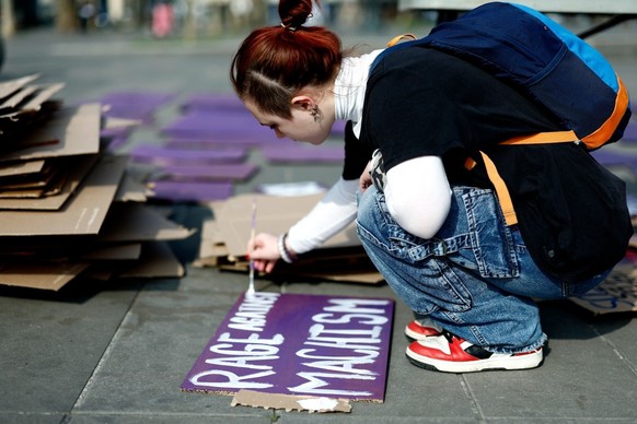 A person prepares a sign reading "Rage against Machism" during a gathering organised by the French collective NousToutes (Us all) as part of the International Women's Day in Paris on Ma ...