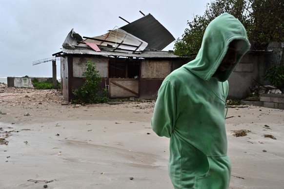 epaselect epa12486754 A man walks by a house damaged by the preliminary winds of Hurricane Melissa at Hellshire Fishing Beach in Portmore, Jamaica, 27 October 2025. Jamaican Prime Minister Andrew Holn ...
