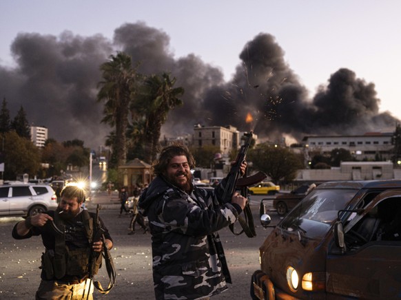 Des Syriens c�l�brent la chute de Bachar al-Assad en tirant en l&#039;air � Damas.