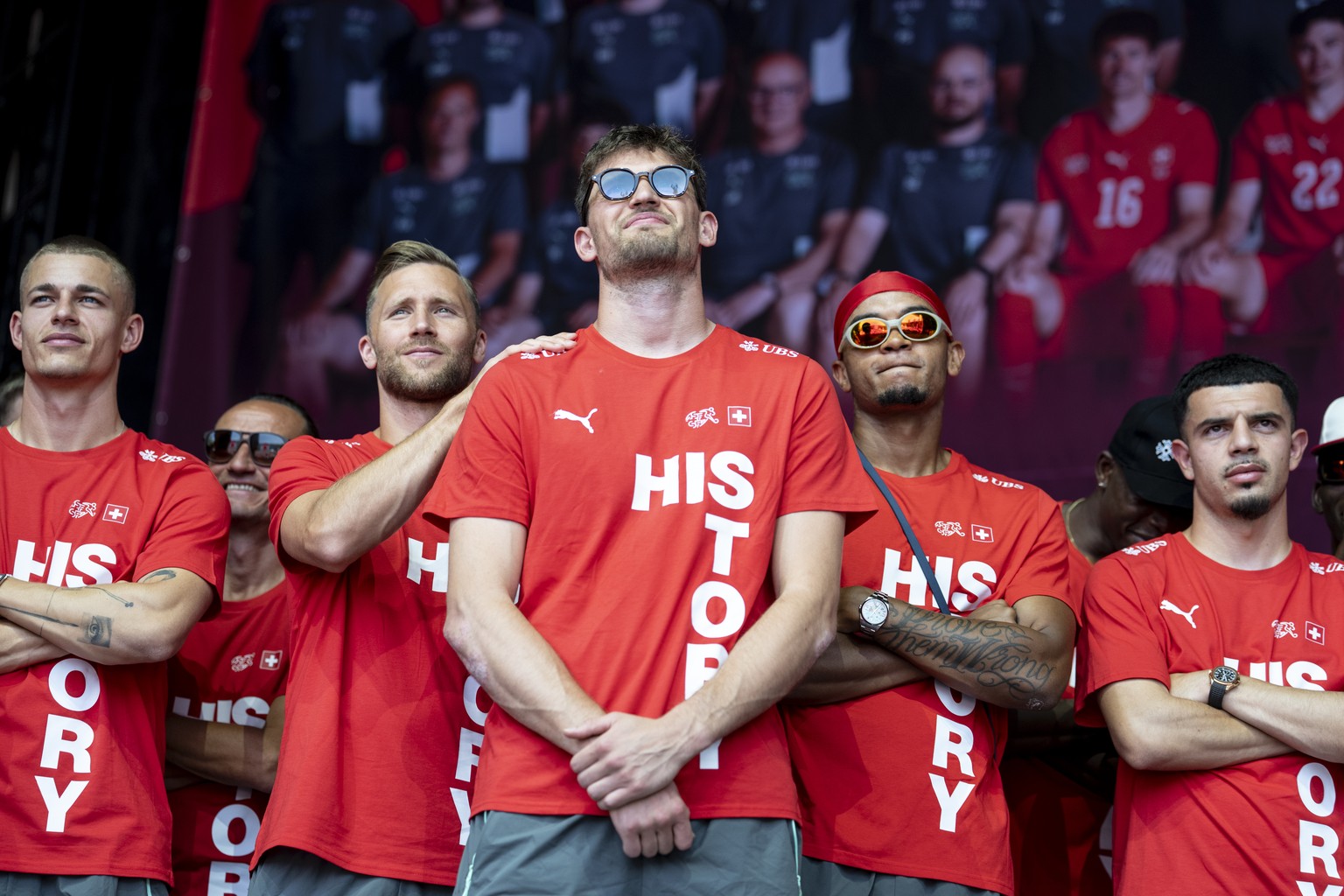 Von links: Miro Muheim, Silvan Widmer, Gregor Kobel, Manuel Akanji und Zeki Amdouni schauen ein Video auf einem Screen beim Empfang der Schweizer Fussball Nationalmannschaft nach dem Aus im Viertelfin ...