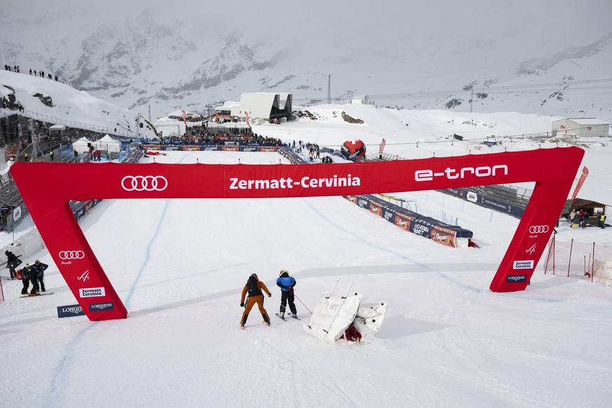 Workers remove an air fence after the women&#039;s downhill race was cancelled due to strong winds, on the new ski course &quot;Gran Becca&quot; at the Alpine Skiing FIS Ski World Cup Zermatt-Cervinia ...
