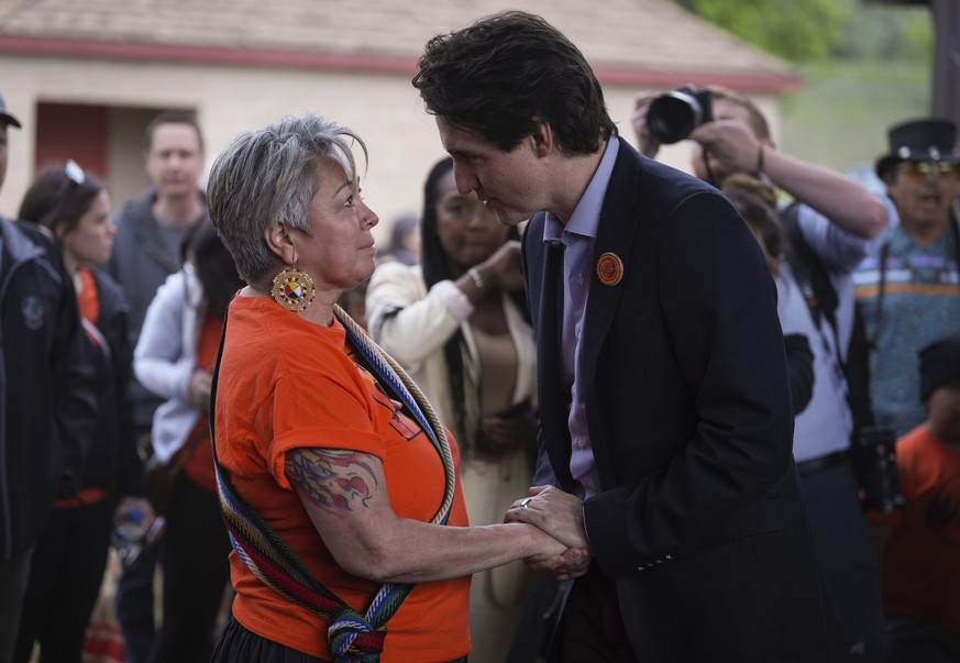 Prime Minister Justin Trudeau speaks with a woman as he leaves after speaking at a ceremony on Monday, May 23, 2022, in Kamloops, British Columbia. The event marked the one-year anniversary of the Tk& ...