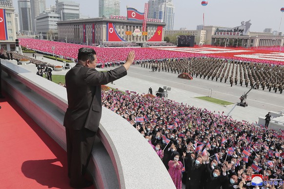 In this photo provided by the North Korean government, North Korean leader Kim Jong Un waves from balcony as he attends a parade to celebrate the 110th birth anniversary of its late founder Kim Il Sun ...