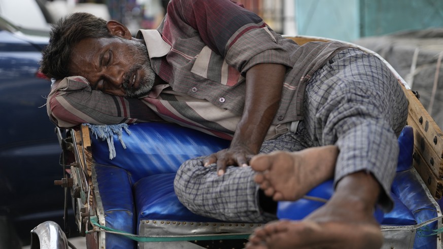 A man sleep on his rickshaw on a hot summer day in Lucknow, in the central Indian state of Uttar Pradesh, Thursday, April 28, 2022. Severe heat wave conditions are sweeping north and western parts of  ...