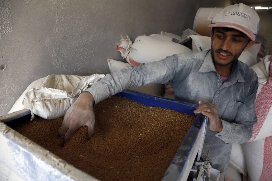 epa09845073 A Yemeni worker grinds imported wheat grain at a flour mill in Sana&#039;a, Yemen, 23 March 2022. The Russian invasion of Ukraine is causing shortages of wheat and food price spikes in war ...