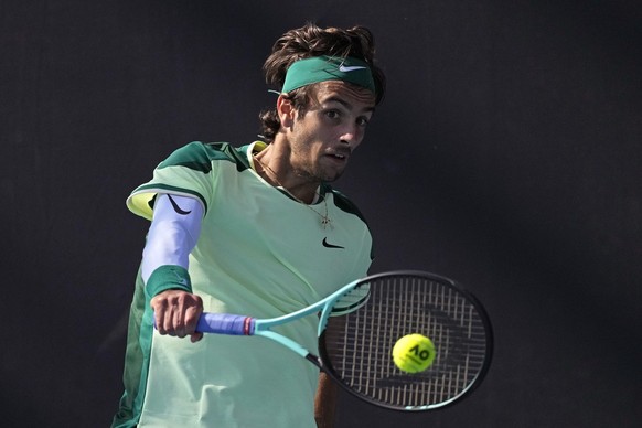 Lorenzo Musetti of Italy plays a backhand return to Luca Van Assche of France during their second round match at the Australian Open tennis championships at Melbourne Park, Melbourne, Australia, Wedne ...