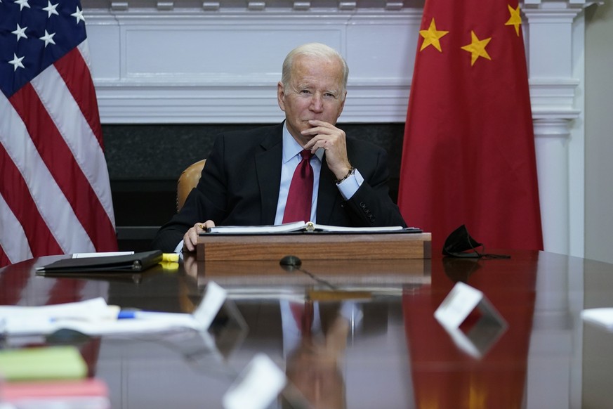 Joe Biden entouré des drapeaux américains et chinois, lors d'une réunion virtuelle avec son homologue chinois, depuis la Maison-Blanche.