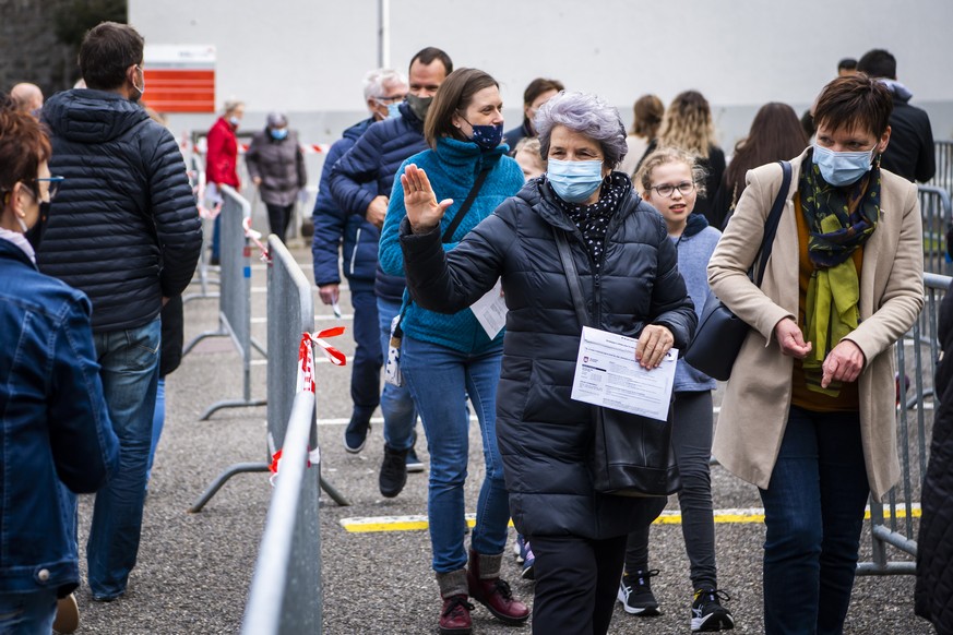 Des personnes font la queue devant l&#039;entree du bureau de vote a la Societ&#039;halle lors de son ouverture le vendredi 26 mars 2021 a Moutier. Le 28 mars 2021 la population de Moutier dira a nouv ...