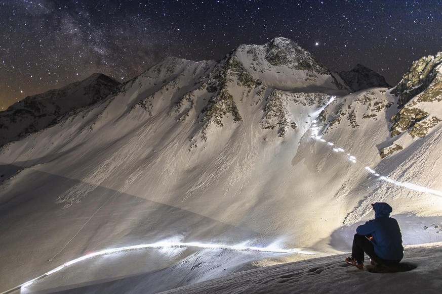 Competitors climb on their way to the &quot;Col De Riedmatten&quot; pass and &quot;Col De Tsena Refien&quot; pass under the milky way, during the 21st Glacier Patrol race near Arolla, Switzerland, thi ...