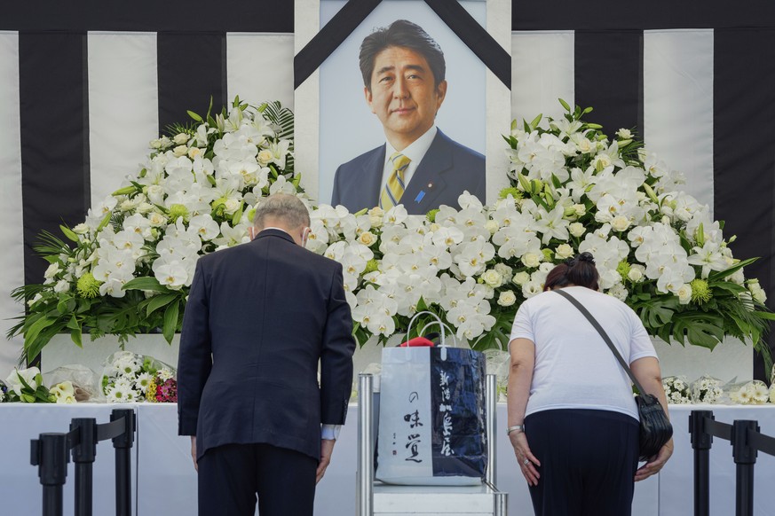 People leave flowers and pay their respects to former Japanese Prime Minister Shinzo Abe outside the Nippon Budokan in Tokyo Tuesday, Sept. 27, 2022, ahead of his state funeral later in the day. (Nico ...