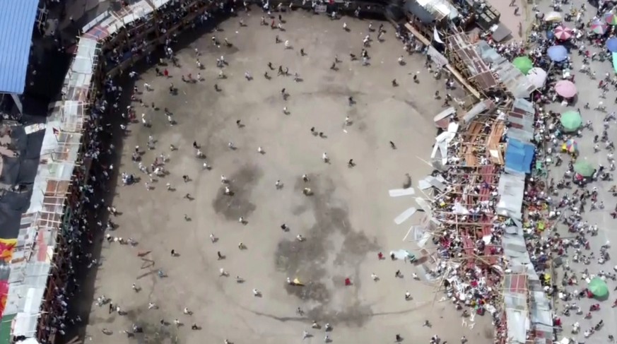 In this image taken from video, spectators are sent plunging to the ground as part of a wooden stand collapses during a bullfight, Sunday, June 26, 2022, at a stadium in the city of El Espinal in Toli ...