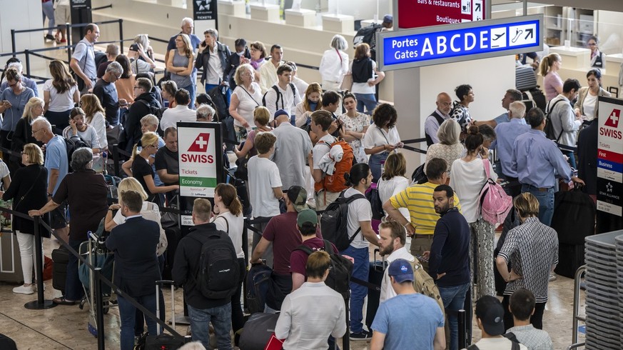 Travellers queue at Geneva Airport, in Geneva, Switzerland, Wednesday, June 15, 2022. After Swiss airspace was closed after a computer glitch with the air traffic control system grounded flights at th ...