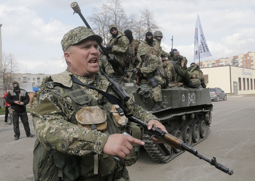 FILE - A pro-Russian separatist clears the way for a combat vehicle in Slovyansk, Ukraine, Wednesday, April 16, 2014. The eastern Ukrainian city of Slovyansk was occupied by pro-Russian separatists fo ...