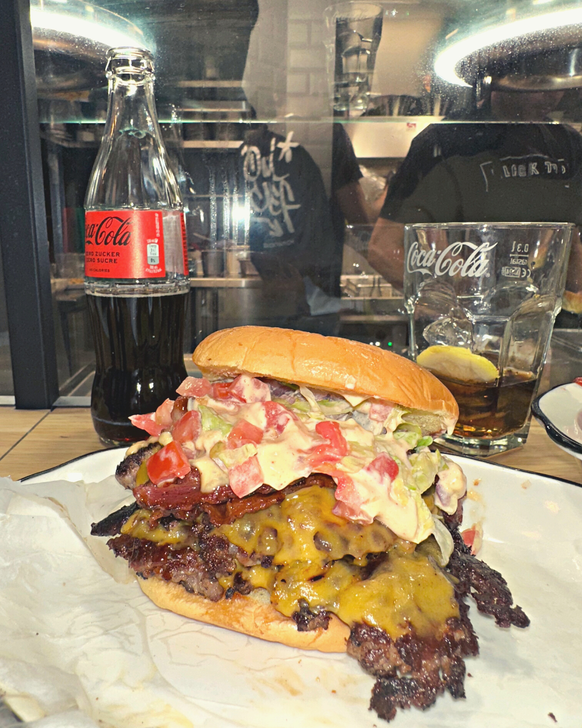 A l'intérieur? Prime burger, aged cheddar cheese, bacon, raw red onions, iceberg, pickle, heritage sauce.