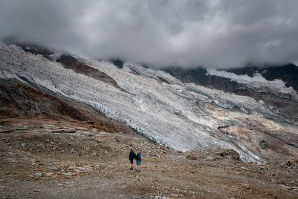 SWISS PRESS PHOTO 23 - 1. PREIS KATEGORIE AKTUALITAET : FABRICE COFFRINI - Tourists are seen next to the Fee Glacier (German: Feegletscher) above the Swiss alpine resort of Saas-Fee on July 30, 2022.  ...