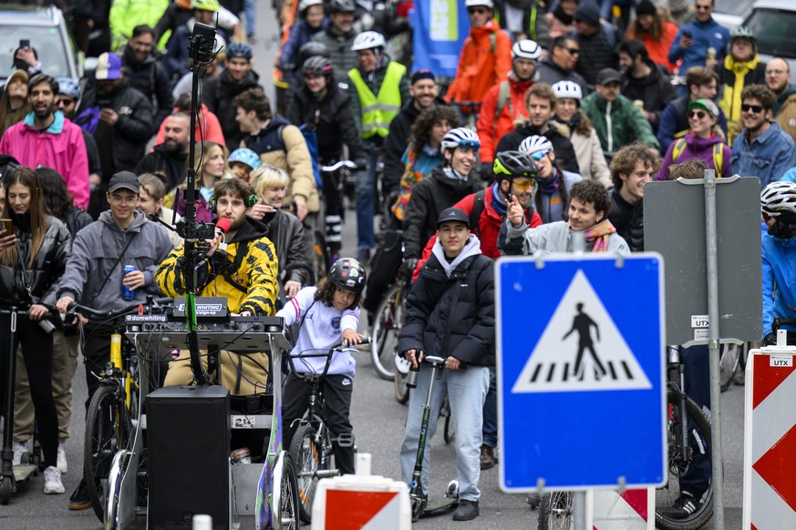 British DJ Dom Whiting, left, better known as the &quot;DJ on the Bike&quot; mixes music while cycling at the head of a parade in bikes during a demonstration by the Association Transports et Environn ...