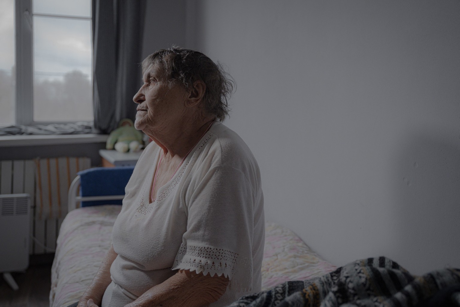 Evacuee Zinaida Gyrenko sits on a bed in her room at a shelter for senior citizens in Kharkiv on March 26, 2025, amid the Russian invasion of Ukraine. The war has disproportionately affected Ukraine&# ...