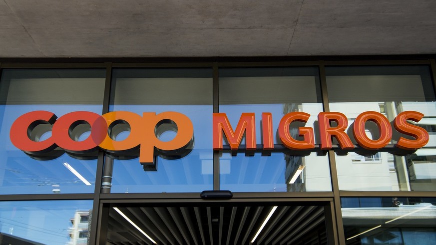Le logo de la Coop et le logo de la Migros sont photographies cote a cote sur un batiment commercial commun ce mardi 23 aout 2016 sur la place de la Sallaz a Lausanne. (KEYSTONE/Jean-Christophe Bott)