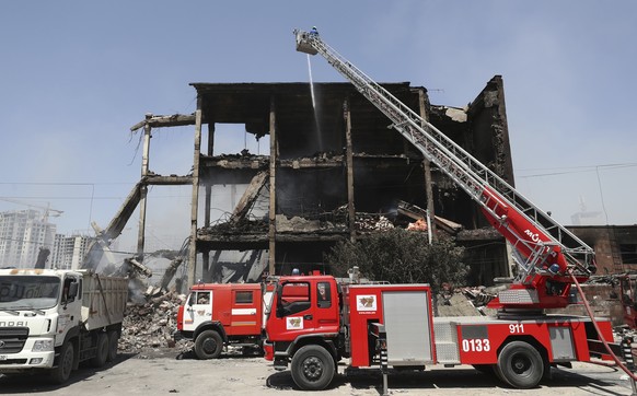 Armenian emergency employees work on the side of burned Surmalu market about two kilometers (1.2 miles) south of the center of Yerevan, Armenia, Monday, Aug. 15, 2022. Armenian officials say that the  ...