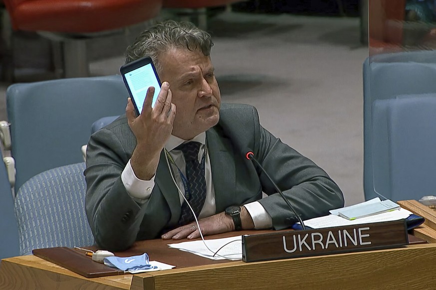 In this image from UNTV video, Ukraine's Ambassador to the United Nations Sergiy Kyslytsya, holds up a phone as he speaks an emergency meeting of the U.N. Security Council Wednesday, Feb. 23, 202 ...