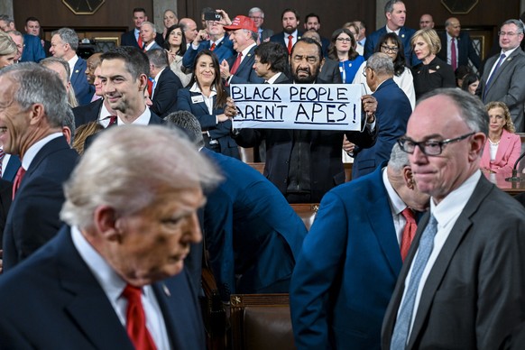 epaselect epa12775135 Representative Al Green (C), Democrat of Texas, holds a sign that reads 'Black people arent apes' before US President Donald J. Trump (L) delivers the first State of th ...