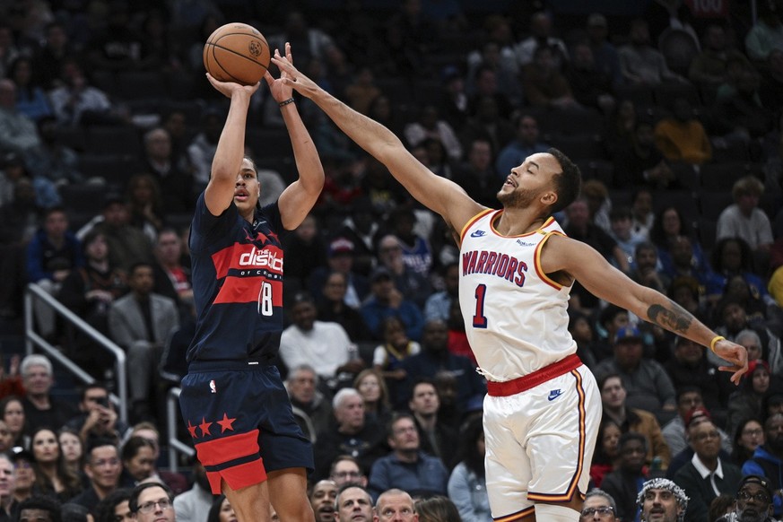 Washington Wizards forward Kyshawn George (18) shoots a three point basket as Washington Wizards guard Johnny Davis (1) defends during the second half of an NBA basketball game, Monday, Nov. 4, 2024,  ...