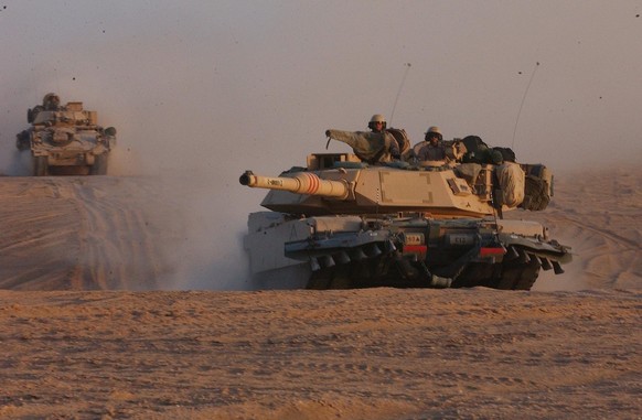 RMG05 - 20030318 - NORTHERN KUWAIT, KUWAIT : A US M1A1 Abrams tank leads the convoy of the US Army 3rd Infantry Division in the northern Kuwaiti desert as the massive US military force moves within st ...