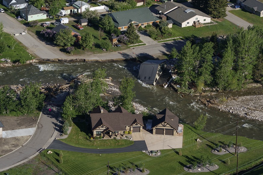 FILE - A house sits in Rock Creek after floodwaters washed away a road and a bridge in Red Lodge, Mont., in Red Lodge, Mont., June 16, 2022. (AP Photo/David Goldman, File)