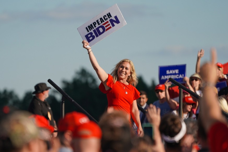 epa09488848 Republican congresswoman Marjorie Taylor Greene waves an &#039;Impeach Biden&#039; placard at a rally sponsored by &#039;Save America&#039; at the Georgia National Fairgrounds in Perry, Ge ...
