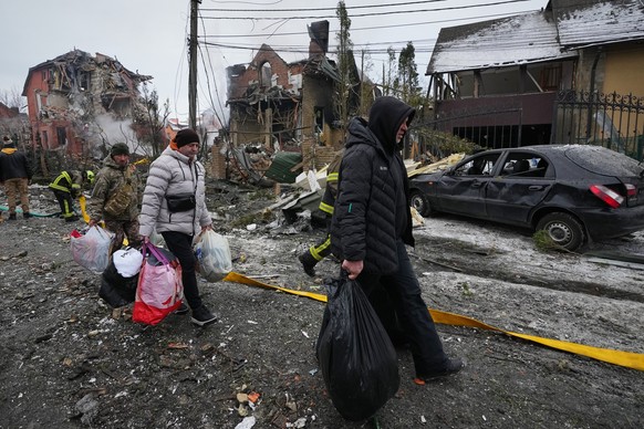 KEYPIX - Local residents carry their belongings as they leave their homes following a Russian drone attack that damaged residential buildings in Kyiv, Ukraine, Sunday, Feb. 22, 2026. (KEYSTONE/AP Phot ...