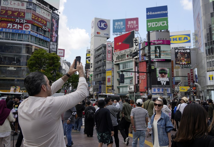 epa11283792 Foreign visitors take pictures at Shibuya crossing in Tokyo, Japan, 17 April 2024. The Japan National Tourism Organization (JNTO) announced that the estimated number of foreign visitors to ...