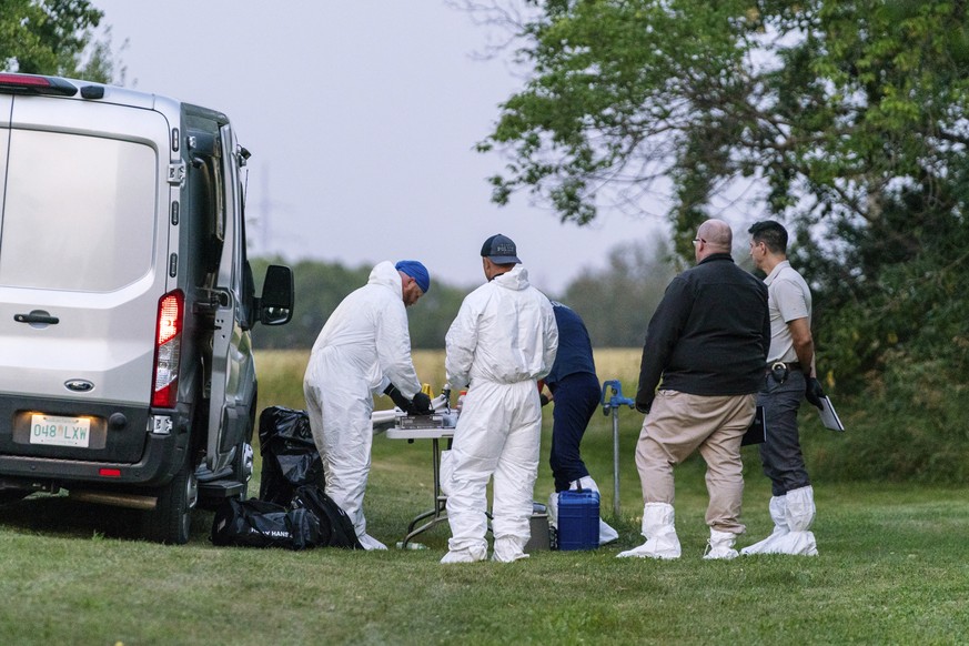 Investigators gather in front of a table near the scene of stabbing in Weldon, Saskatchewan Sunday, Sept. 4, 2022. A series of stabbings at an Indigenous community and at another in the village of Wel ...