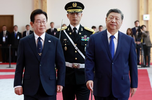 epa12496716 South Korean President Lee Jae Myung (L) and Chinese President Xi Jingping (R) inspect an honor guard during a welcome ceremony ahead of their talks at the Gyeongju National Museum in Gyeo ...