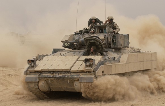 041030-F-2034C-040
An M2A2 Bradley Fighting Vehicle kicks up plumes of dust as it leaves Forward Operating Base MacKenzie in Iraq for a mission on Oct. 30, 2004. The Bradley is assigned to Alpha Troop ...