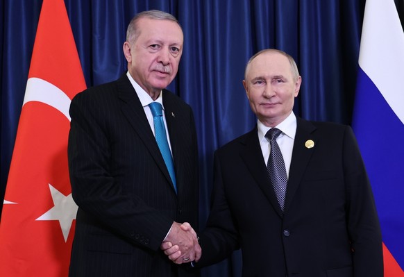 epa12342162 Turkish President Recep Tayyip Erdogan (L) and Russian President Vladimir Putin shake hands as they pose for a photograph before a bilateral meeting on the sidelines of the Shanghai Cooper ...