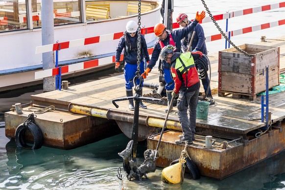 Des ouvriers travaillent au repechage de l'un des ancres et de sa chaine du bateau de la CGN Montreux lors d'une operation de renflouage devant le debaquadere du Mont-Blanc, ce lundi 23 mars ...