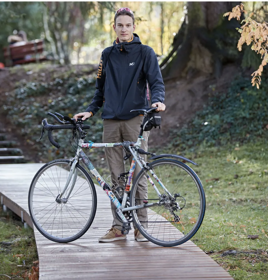 Riwal Leemann avec son vélo dans un parc à Fribourg